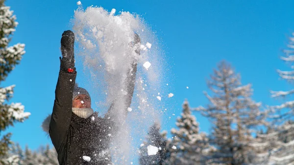 Gülümseyen kadın havaya kar fırlatır ve kollarını uzatır.. — Stok fotoğraf