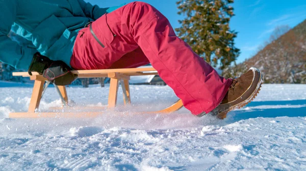 LOW ANGLE, CLOSE UP: Unrecognizable young woman sleds across the snowy meadow. — Stock Photo, Image