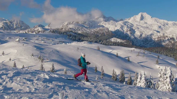Молодая туристка спускается со снежного холма во время лыжного тура. — стоковое фото