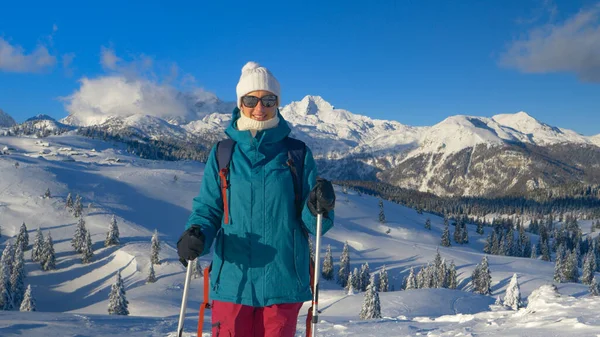 PORTRAIT: Wesoła kobieta na nartach uśmiecha się podczas odpoczynku na śnieżnej górze. — Zdjęcie stockowe