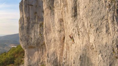 Korkusuz erkek turist Crni Kal 'da ünlü bir tırmanma duvarına tırmanıyor..