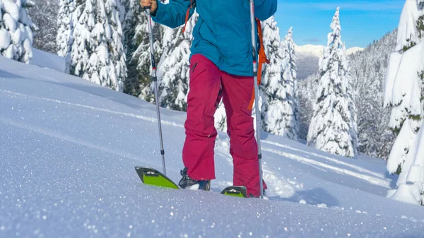 低角度：难以辨认的女分开者爬上闪闪发光的雪地草地 — 图库照片