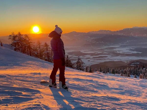 Dişi snowboardcu, inmeden önce altın ışıklı vadiyi gözlemliyor. — Stok fotoğraf