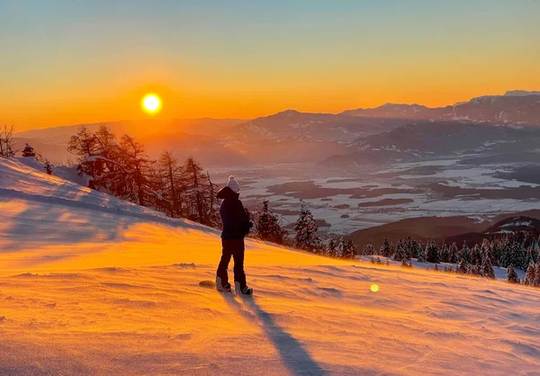 Dişi snowboardcu inmeden önce altın ışıklı vadiyi gözlemliyor. — Stok fotoğraf