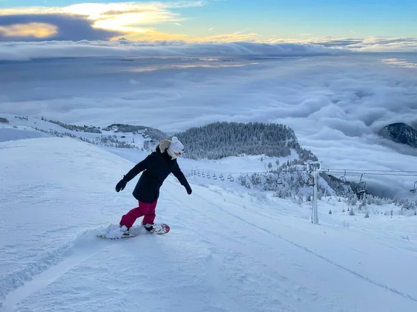 Fit female tourist snowboards the ungroomed slopes near a ski resort in Slovenia — Stock Photo, Image