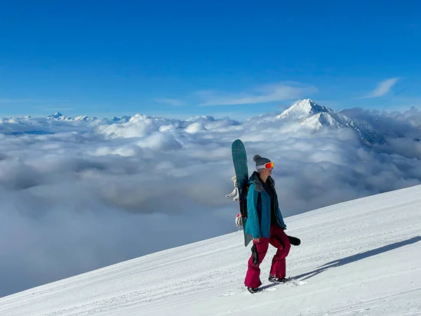 Jeune femme snowboard en station de ski fermée Krvavec monte une pente damée. — Photo