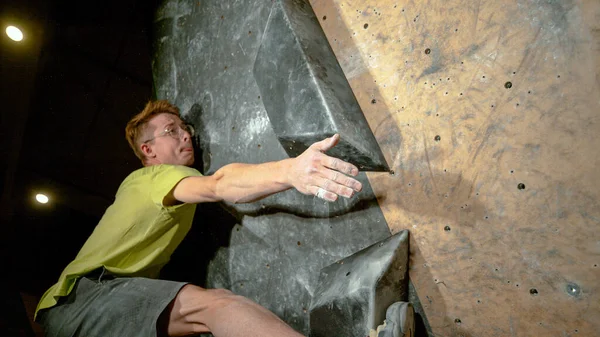 FECHAR-se: Alpinista atinge até para segurar um porão durante o treinamento no centro interior. — Fotografia de Stock