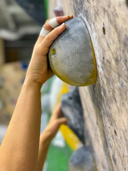 VERTICALE, CHIUSO: L'arrampicatrice donna irriconoscibile pende da pendii gialli. — Foto Stock