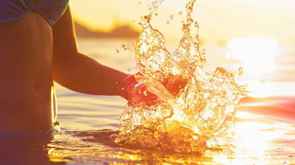 レンズフレア:夏の休暇中に女性の観光客が海の水をスプラッシュフィット. — ストック写真
