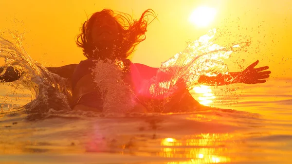 Genç bir kadın kollarını açmış, sakin okyanus suyuna düşüyor. — Stok fotoğraf