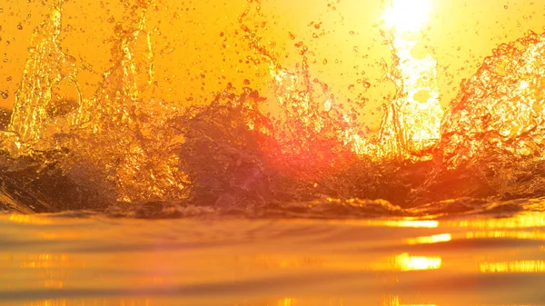 LENS FLARE: Detailed shot of glassy ocean water splashing into evening sky. — ストック写真