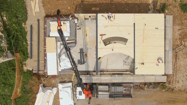 Çağdaş çapraz kaplamalı ahşap bir ev inşa ederek müteahhitlerin üzerinden uçuyor.