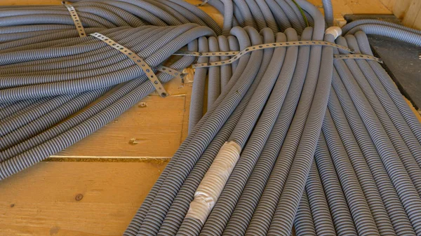 Oluklu pvc tüpleri ahşap bir evin zemininden geçiyor..