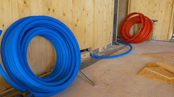 FERMER : Bobine de tube en caoutchouc bleu est déroulé sous la paroi en bois. — Photo