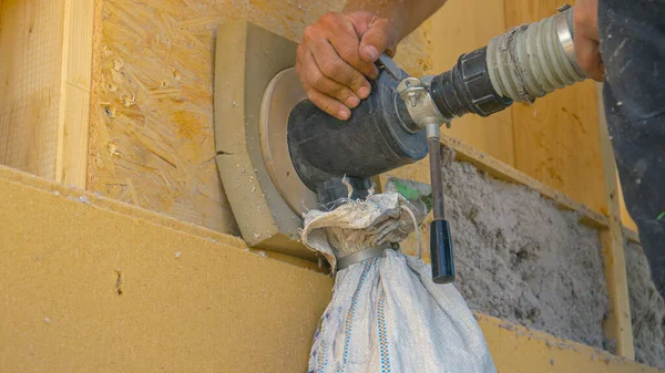 ZAMKNIJ SIĘ: Budowniczy używa dmuchawy do izolowania ściany drewnianej papierem z recyklingu. — Zdjęcie stockowe