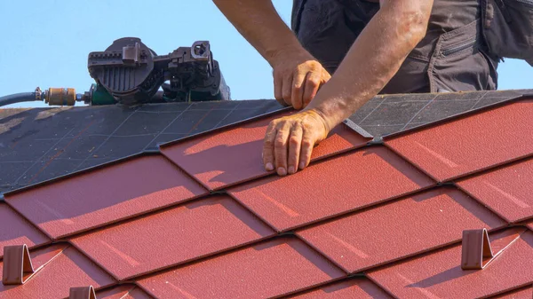 FECHAR UP: Construtor de canteiros de obras ajuda a colocar o telhado no topo de uma casa moderna. — Fotografia de Stock