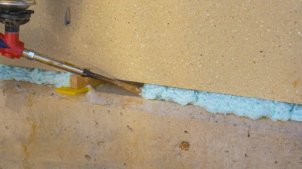 CLOSE UP: Contractor fills up a crease in the wall with polyurethane foam. — Stock Photo, Image