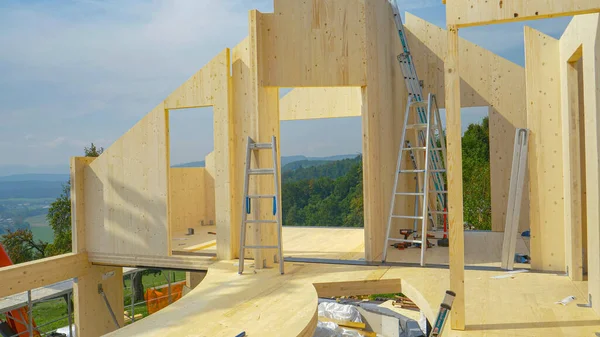 Çatısı olmayan bitmemiş CLT evi manzaralı kırsal kesime bakıyor..
