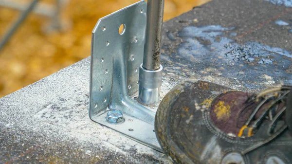 Bezárás: Építő használ egy fúró, hogy rögzítse a csavar a beton alapjait. — Stock Fotó
