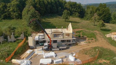 Gökyüzü yeşili kırsalda yapım aşamasındaki evin etrafında uçmak.