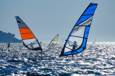 Adriyatik 'te popüler sörf merkezleri gün batımında rüzgar sörfçüleriyle dolu.