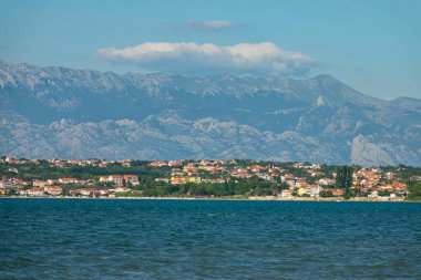 Deniz kenarındaki yazlıklar Velebit dağlarının eteklerine kadar yayılmış.