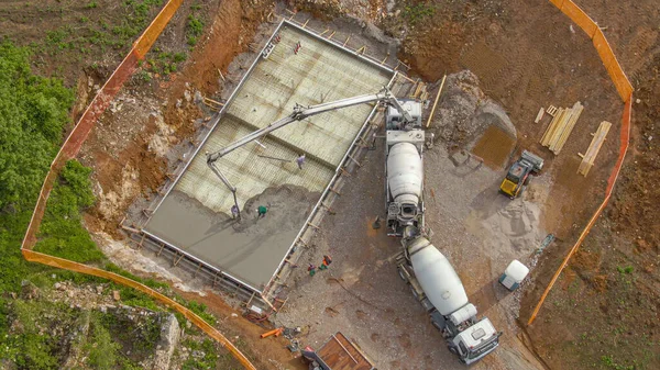 DRONE: Construction site crew pump cement onto the base for modern house. — ストック写真