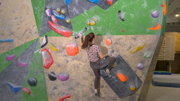 CERRAR: Mujer ágil irreconocible sube a una ruta de bouldering interior. —  Fotos de Stock