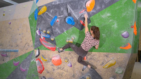 AFSLUITEN: Fit blanke vrouwelijke atleet treinen in een indoor bouldering faciliteit. — Stockfoto