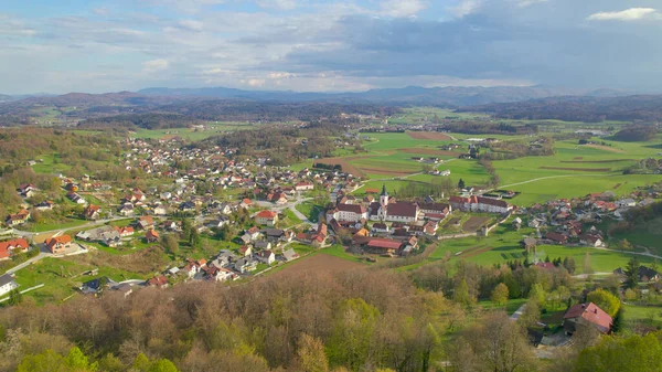 DRONE: Liten kloster i utkanten av en by i pulserande grön landsbygd Slovenien. — Stockfoto