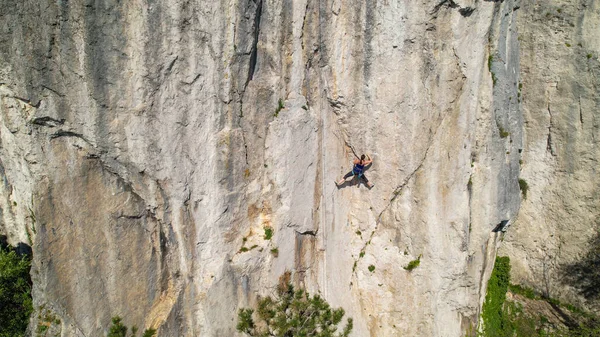 DRONE: Ženský horolezec, který se učí šplhat po laně, hledá pevnost v přírodní stěně. — Stock fotografie