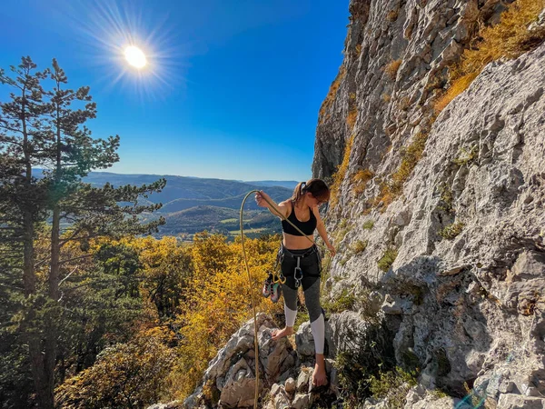 LENS FLARE: Young woman prepares the belay rope before climbing in Crni Kal. — Stock Photo, Image
