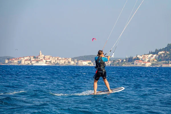 FECHAR-SE: Mulher atlética foilsurfs perto da cidade velha de Korcula em um dia ensolarado — Fotografia de Stock