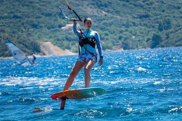 CERRAR: Ajustar los surfistas turísticos femeninos en una tabla de láminas a lo largo de la península de Peljesac. — Foto de Stock