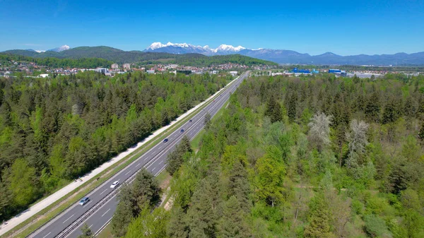 AERIAL: Vliegen langs een brede snelweg die leidt naar de rand van Ljubljana. — Stockfoto