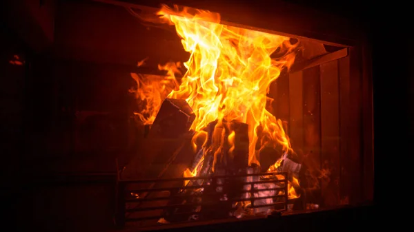 FECHAR: Fotografia idílica de troncos queimando dentro de um incêndio em uma sala de estar escura. — Fotografia de Stock