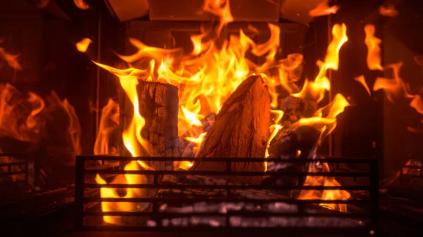 CHIUSURA: Grande fuoco brucia all'interno di una fossa di fuoco nel mezzo di un salotto buio — Foto Stock
