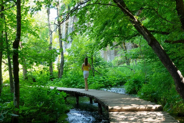Jonge vrouwelijke reiziger op zomervakantie verkent prachtige Plitvice meren park. — Stockfoto