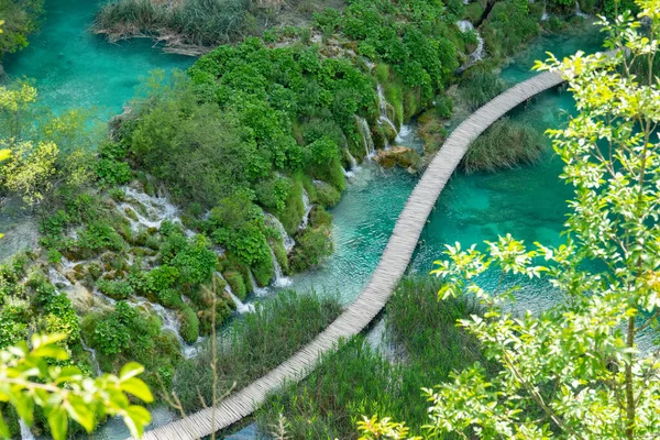 AERIAL: Houten wandelpad kruist een meer in een toeristische attractie in Kroatië. — Stockfoto