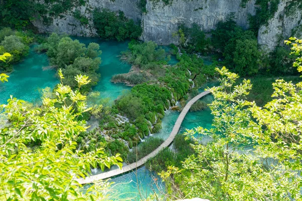 Üres sétányon fut el egy smaragd tó a festői Plitvice Nemzeti Park. — Stock Fotó