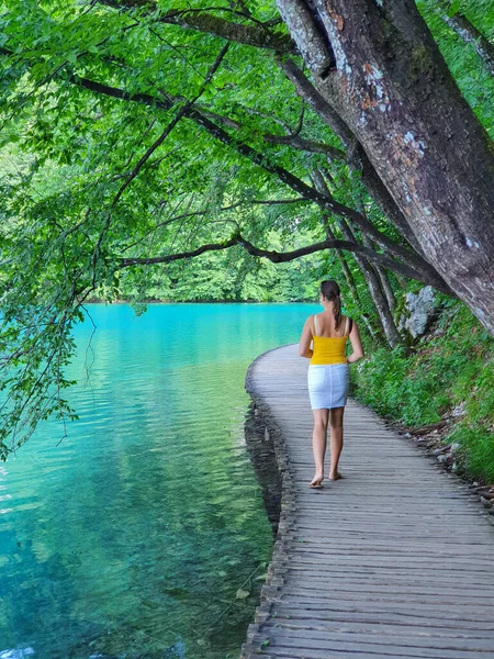 VERTICAL: Onherkenbare vrouw verkent het pittoreske Nationaal Park Plitvice. — Stockfoto