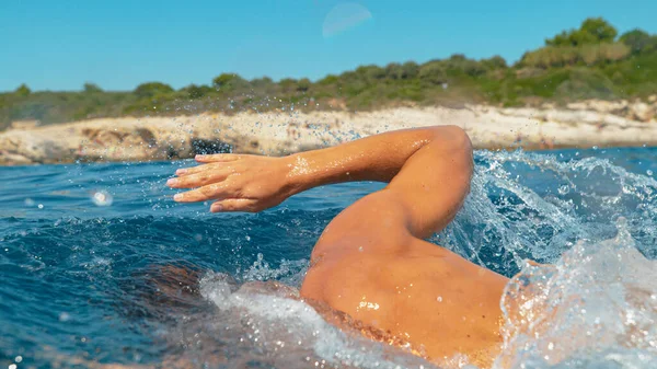 가까이 다가가 다: 어느 화창 한 여름날인지 식별 할 수없는 운동 선수 가 바다에서 수영을 한다. — 스톡 사진