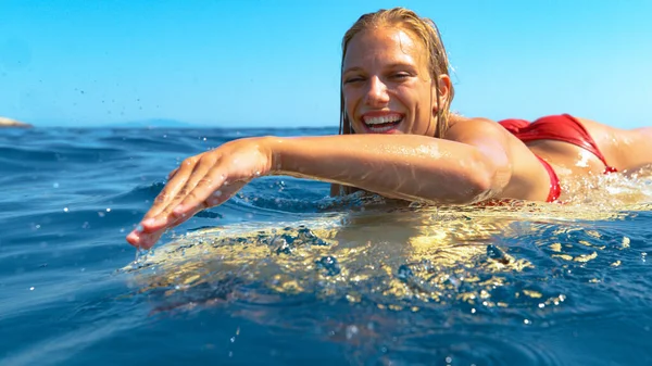 PORTRAIT: Ung kvinnlig turist njuter av sin semester genom att surfa på en solig dag. — Stockfoto