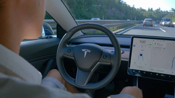 Genç banliyö çalışanı, otomatik çalışan bir Tesla aracıyla işe gidiyor..