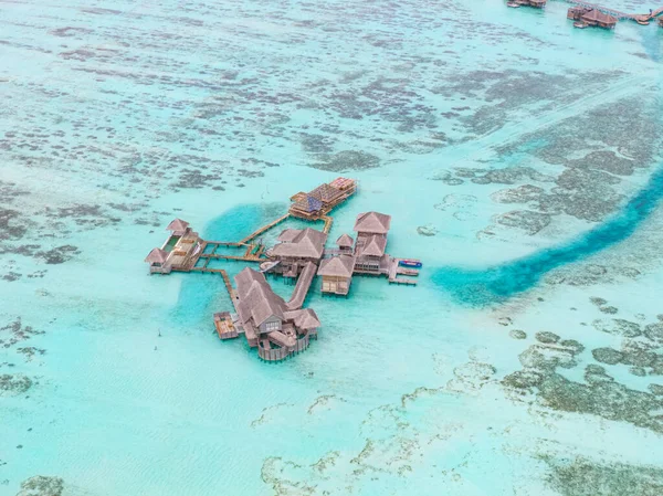 AERIAL: Fliegen in der Nähe einer wunderschönen exotischen Insel und leeren Überwasser-Bungalows — Stockfoto