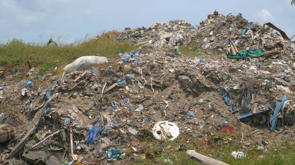 CLOSE UP: Berge von verbranntem Plastik liegen in der Nähe eines tropischen Waldes auf einer abgelegenen Insel. — Stockfoto