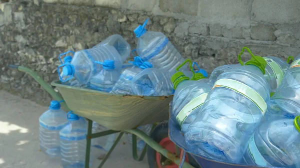 FECHAR, DOF: Dois carrinhos de mão são preenchidos com garrafas de água de galão vazias. — Fotografia de Stock