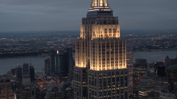 AERIAL: Spektakulär bild av Empire State Building upplyst mitt i natten — Stockvideo