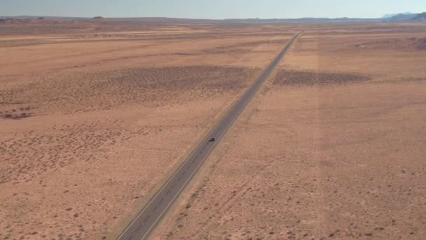 AERIAL: Volando por encima de la carretera interestatal vacía cruzando las llanuras áridas. — Vídeo de stock