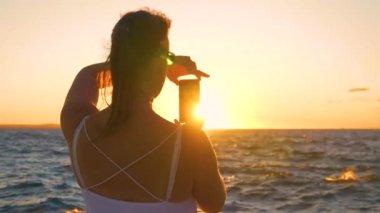 Dişi gezgin, Adriyatik Denizi 'nin ardında güneşin batışının fotoğraflarını çekiyor..